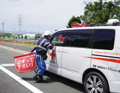 交通管理員の誘導に従い通行する日本赤十字社の車両