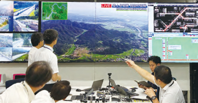 自衛隊のヘリコプター映像を確認しながら情報共有する様子