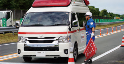 交通管理員の誘導により通行する救急車