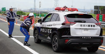 交通管理員の誘導に従い通行する警察車両
