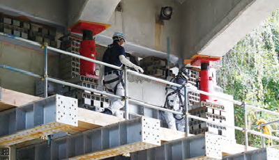 鋼製支保工上で片野川橋をジャッキアップする作業