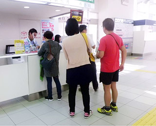 福岡空港国際線レンタカー窓口で手続き中の外国人旅行客