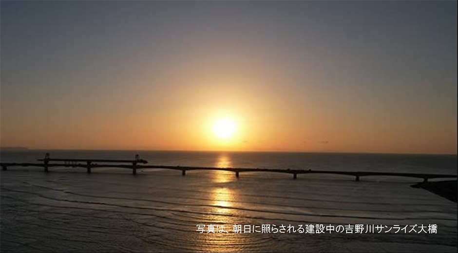 写真は、朝日に照らされる建設中の吉野川サンライズ大橋